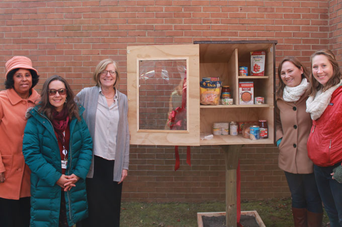 Staff and volunteers standing next to Little Free Pantry at Hutcherson