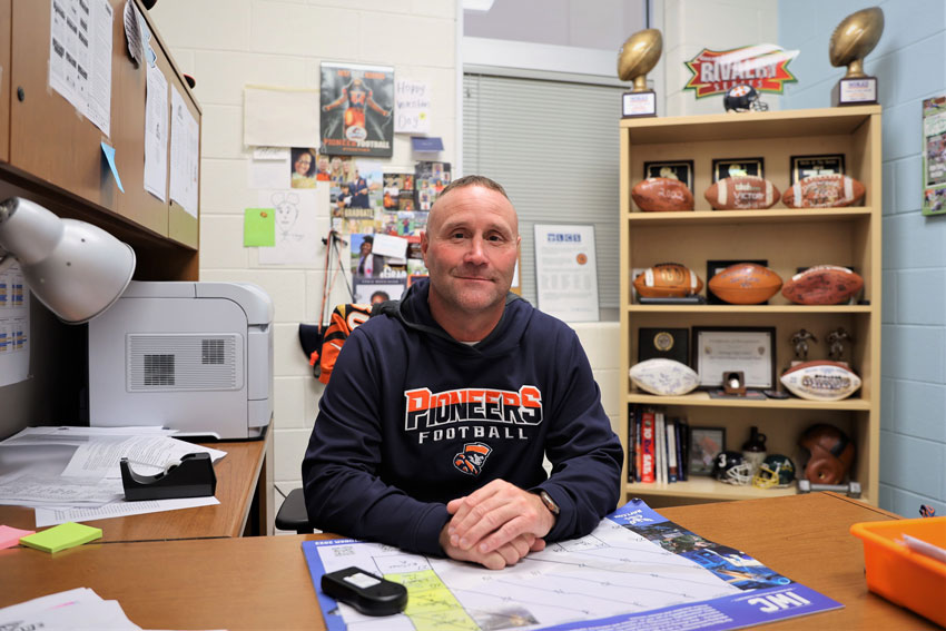 Coach Brad Bradley sitting at his desk in his office