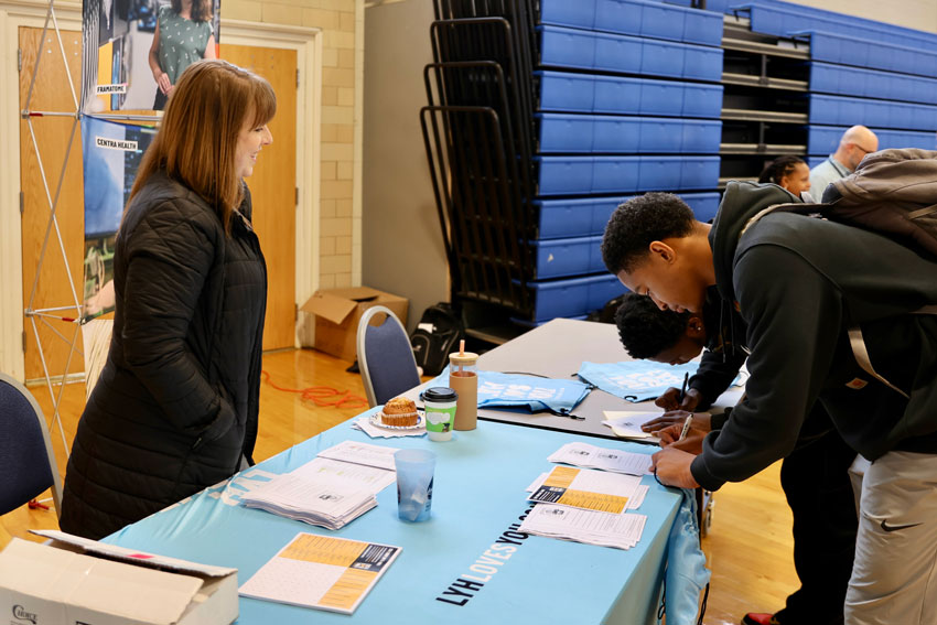 Students signing papers at table during career fair
