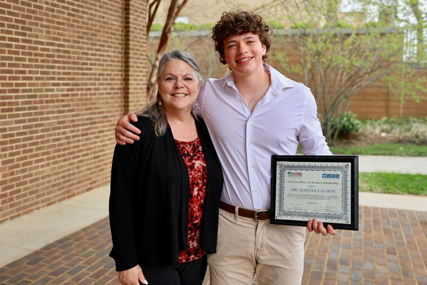 Micajah Mason with his mother holding Excellence in Science Scholarship award 