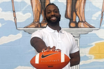 Coach Kenneth “KJ” Bryant holding football