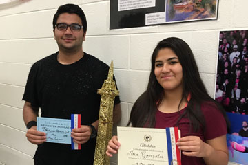 Two students holding French writing competition awards