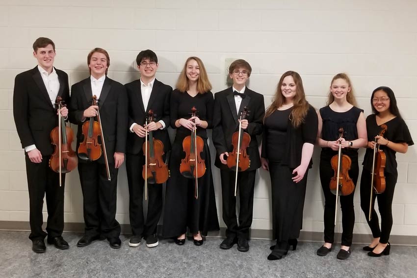 Eight orchestra students together in performance attire