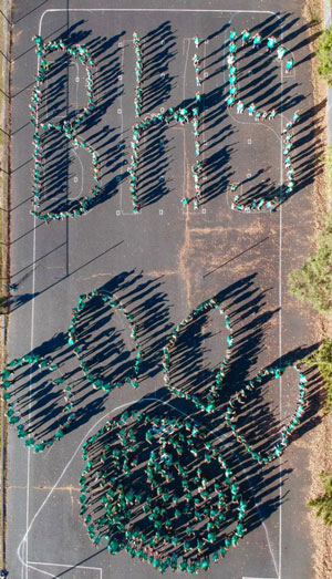 Drone photo of students positioned to spell out BHS and Husky paw logo