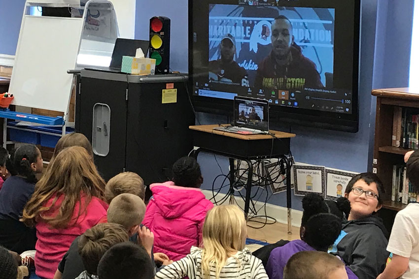 Students in classroom video chat with NFL players