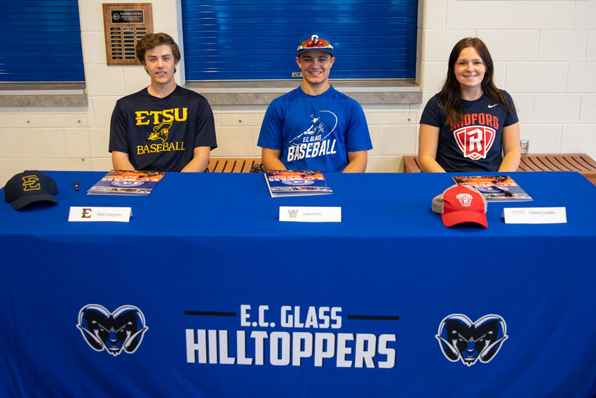3 students sitting at table covered with EC Glass Hilltoppers tablecloth