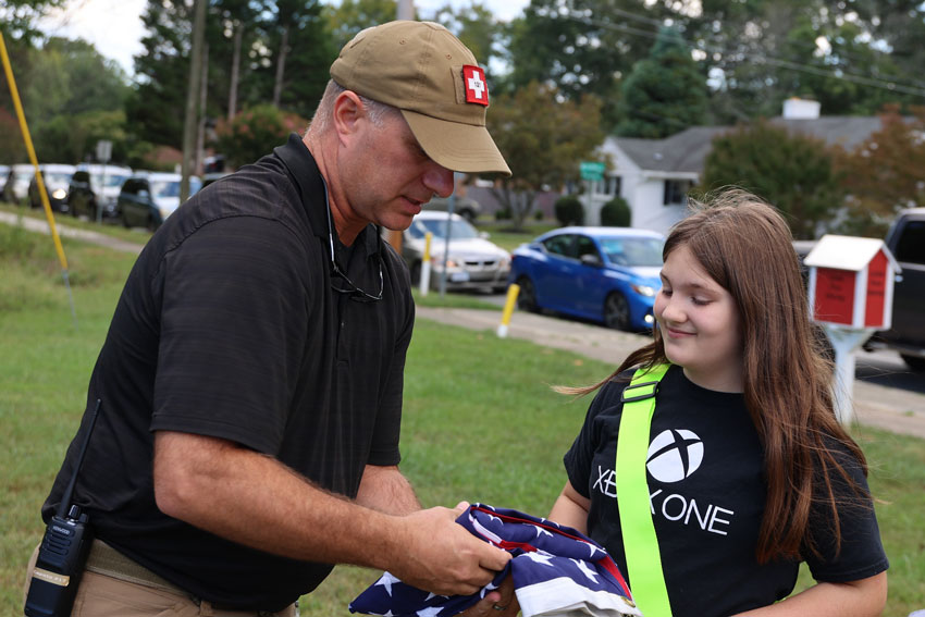 School Security Officer with student holding flag