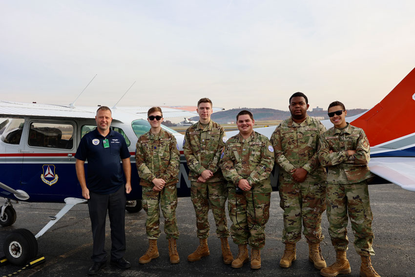 JROTC students with instructor standing in front of plane