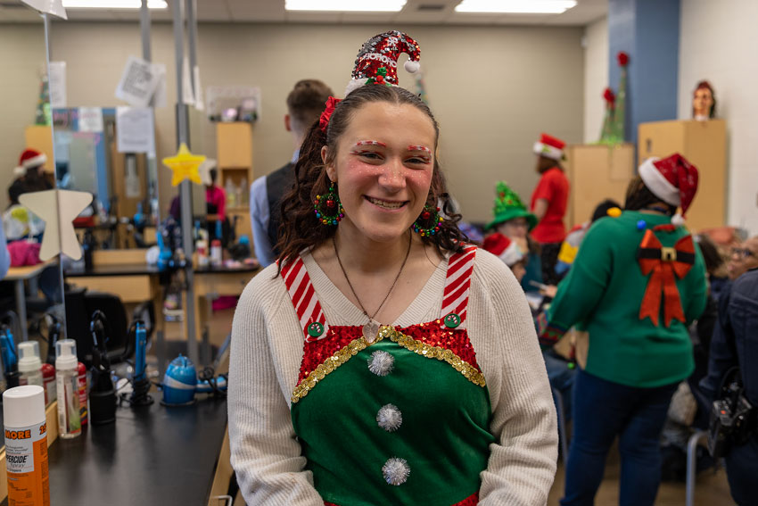 Student wearing holiday outfit in cosmetology classroom
