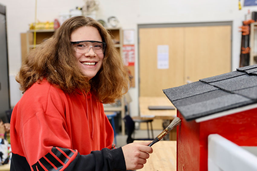 Student painting Little Free Library