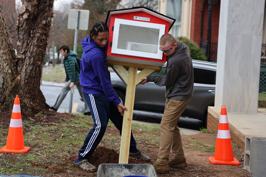 Students installing Little Free Library in front of School Administration Building