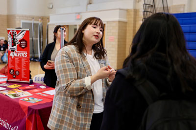 Adult speaking to student at career fair