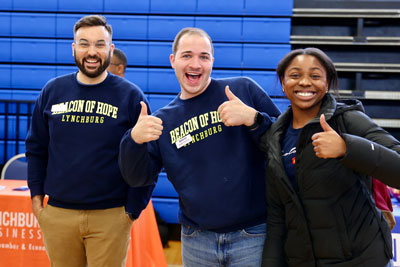 Two Beacon of Hope staff members with student smiling