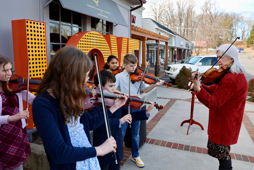 Strings teacher with students outdoors