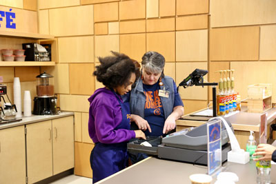 Student and school staff at cash register