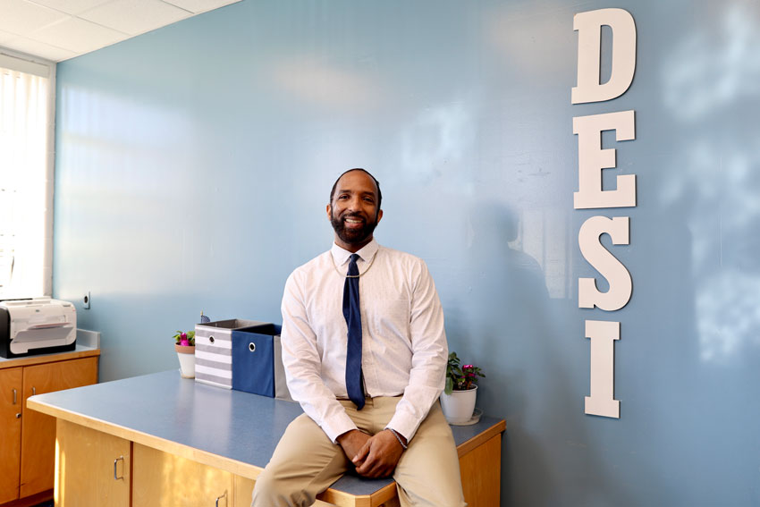 Jason Giambrone next to "DESI" wall decoration