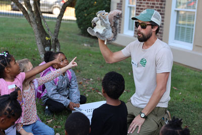 Camp Kum-Ba-Yah volunteer speaking with students outside