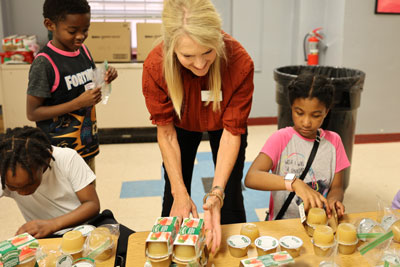 Park View Community Mission volunteer packing meals with students