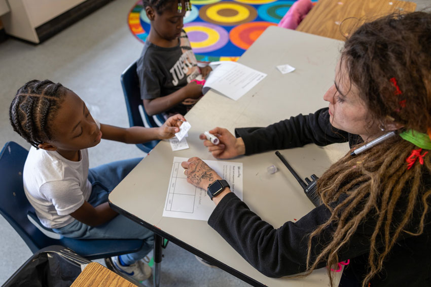 Behavior coach working with students at table