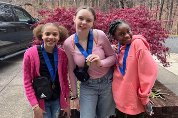 Three students wearing VA History Day 1st place medals