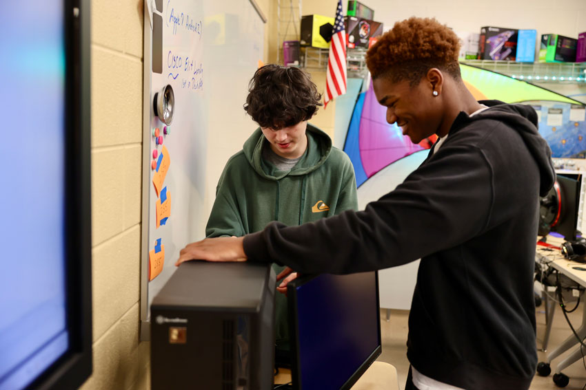 Two students working on computer hardware
