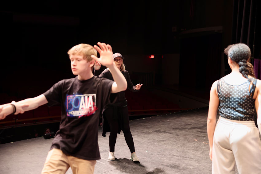 Choreographer on stage working with students at rehearsal