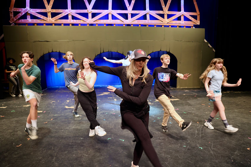 Choreographer demonstrating dance steps for students at rehearsal
