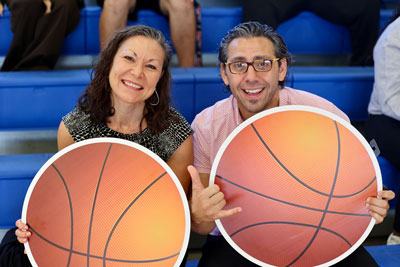 Two people holding basketball signs during game