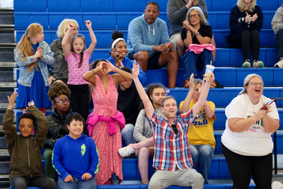 Students and teachers cheering during basketball game
