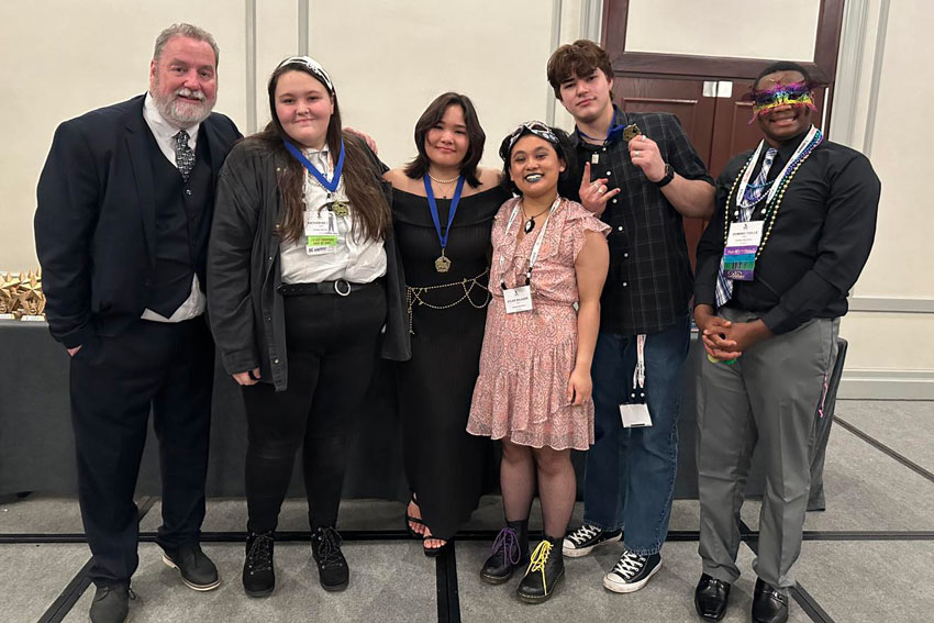 Teacher with students at theatre competition