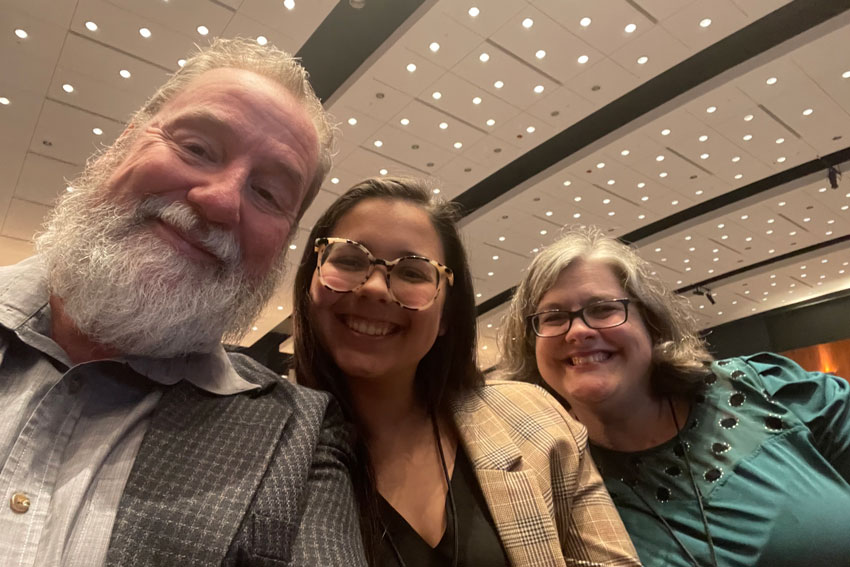 Three staff members seated together at event