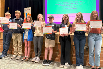 Eight middle school students holding certificates