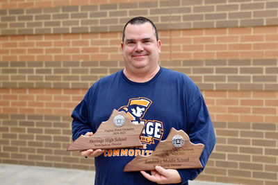 Teacher holding two awards