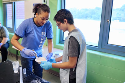 Teacher working with student to mix dental mold