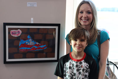 Student with mother in front of artwork on display