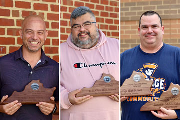 Three teachers holding awards
