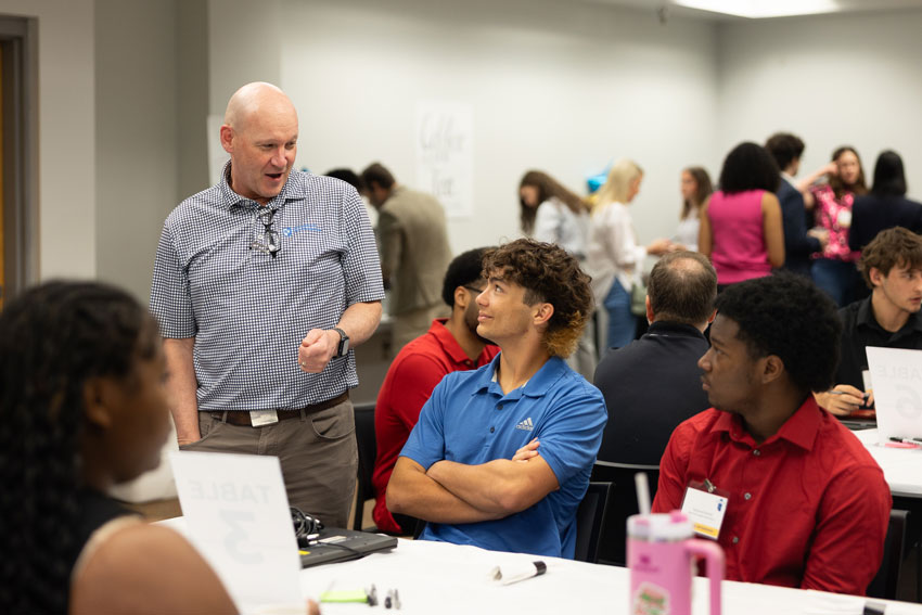 Community partner speaking to students in crowded room