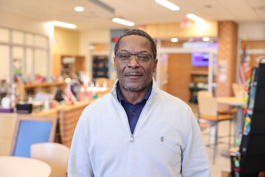 Andrew Kelso standing in school library