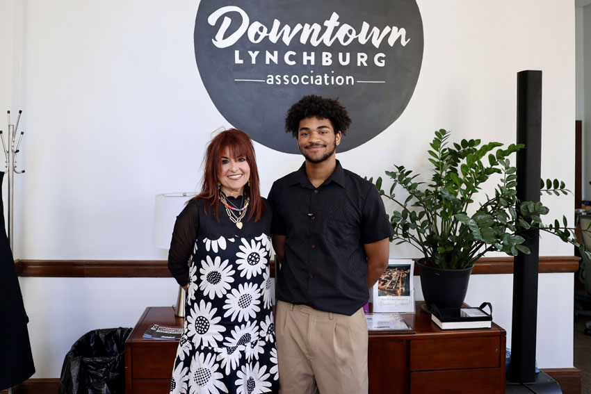 Woman and student standing in front of Downtown Lynchburg Association sign