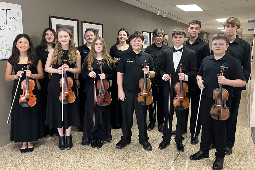 Group of 12 secondary students in concert attire holding stringed instruments