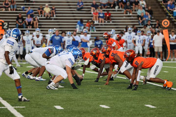 E. C. Glass and Heritage football players at the line of scrimmage
