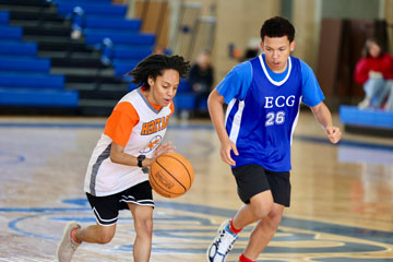 Heritage basketball player dribbling ball near E. C. Glass defender