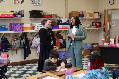 Teacher speaking to Superintendent in classroom