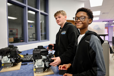 Two students working on engine