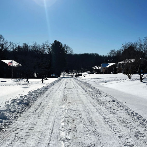 Neighborhood street still covered in snow after being plowed