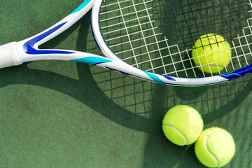 Tennis racket and balls on court
