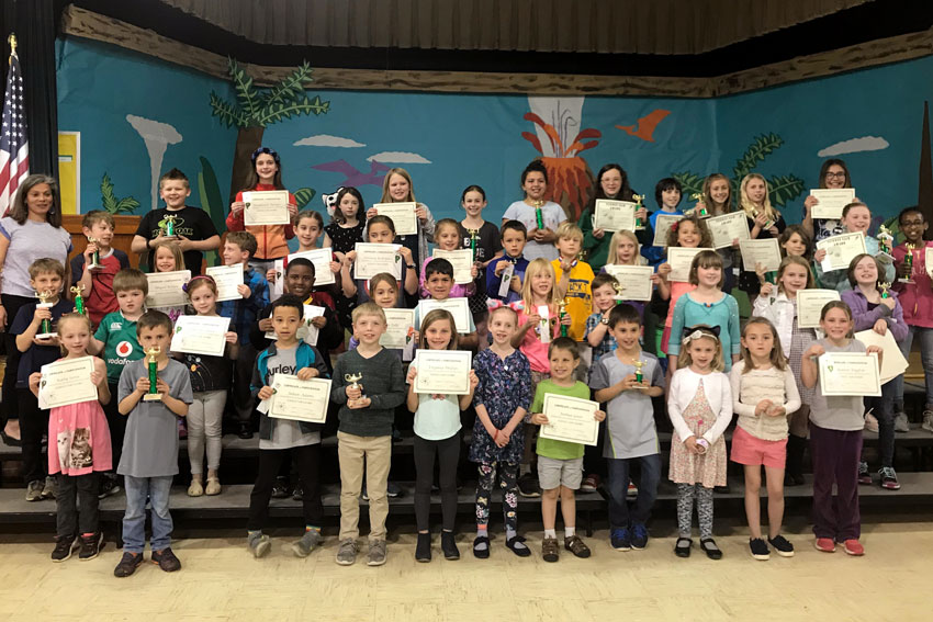 Science Fair participants on stage holding certificates and trophies