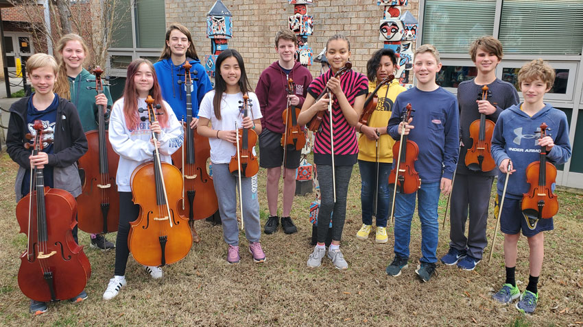 Students standing outside with string instruments