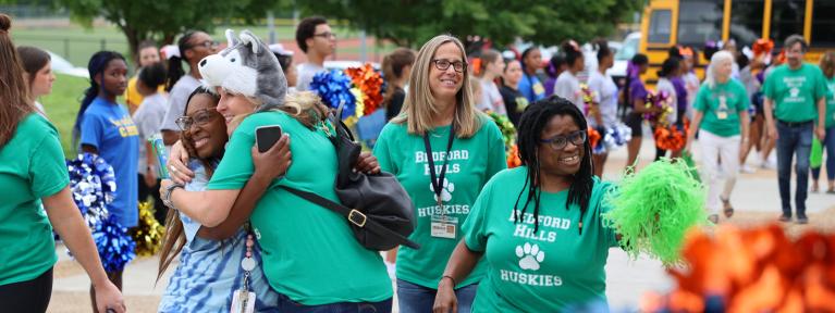 Teachers in matching shirts walking into staff event