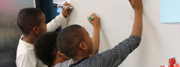 Boys working math problems on board